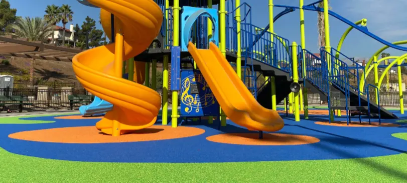 Commercial playground with colorful poured-in-place rubber safety surfacing designed to reduce playground fall injuries and improve accessibility
